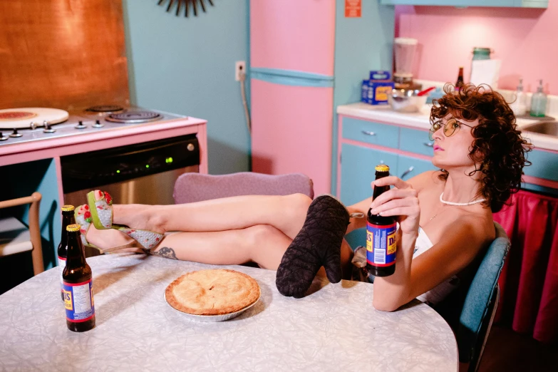 a woman sitting on a chair next to a table with bottles of soda