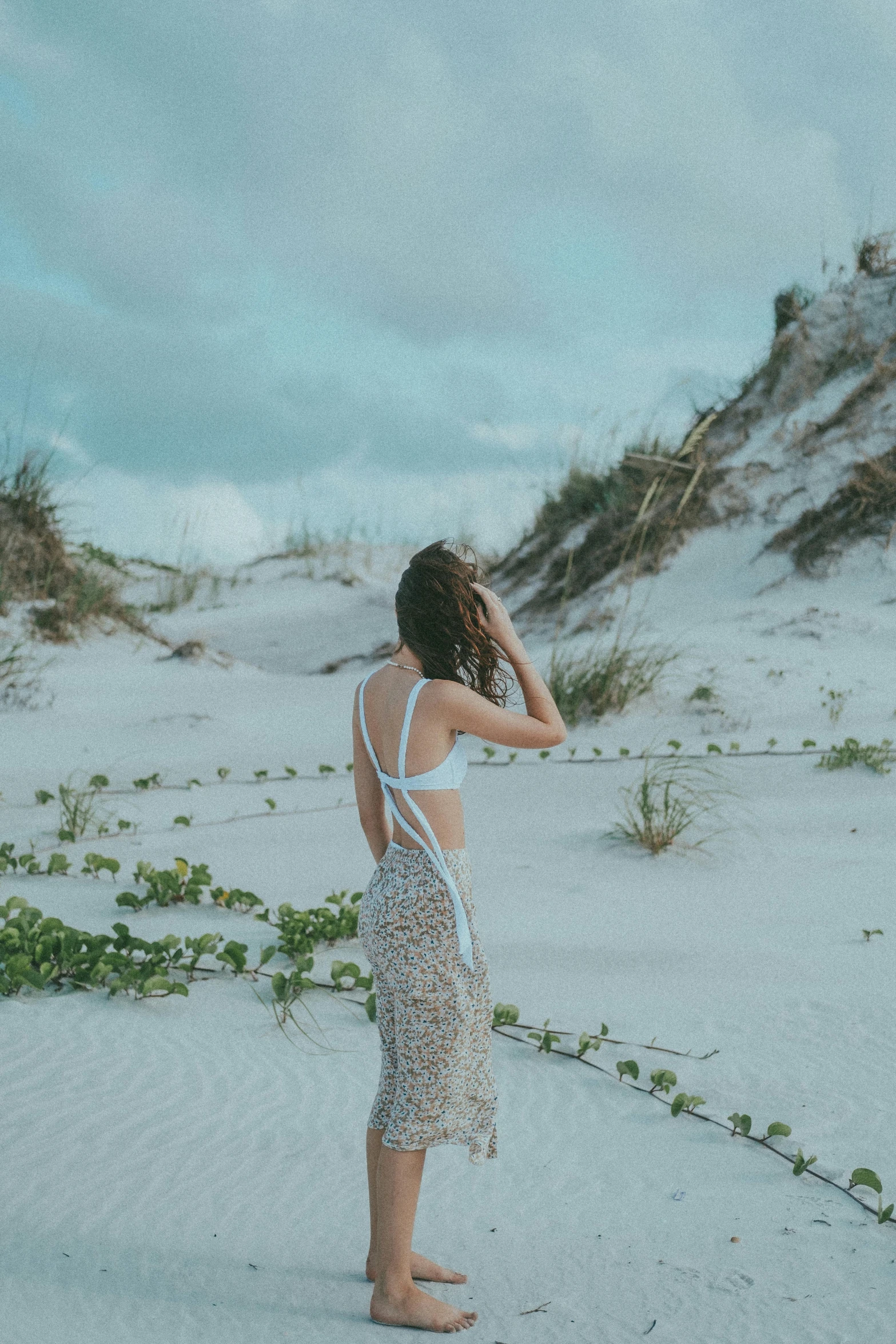 a woman standing on top of a sandy beach