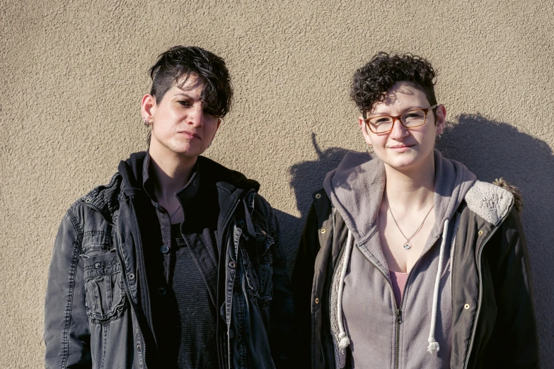 two people in front of a wall pose for the camera