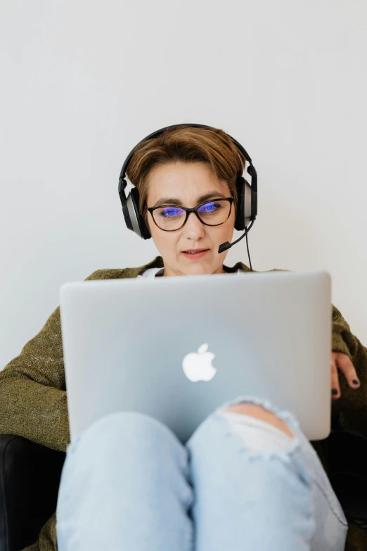 an older woman with headphones and a laptop