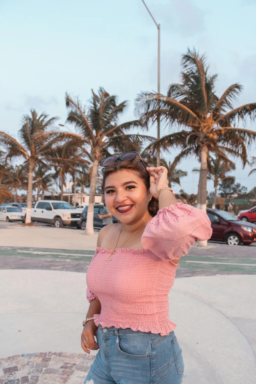 a person in a parking lot with palm trees