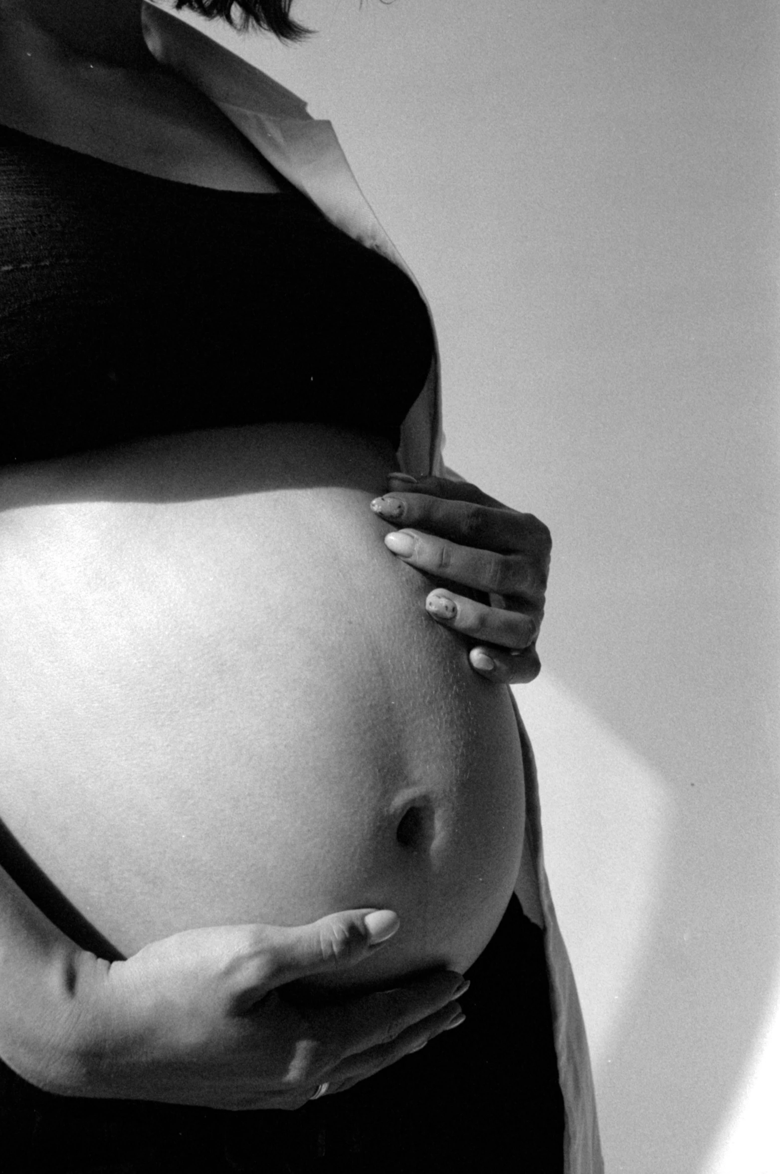 a pregnant woman holding her belly with both hands