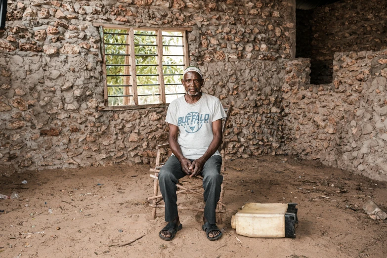 a man sitting in a chair in a room next to a wall