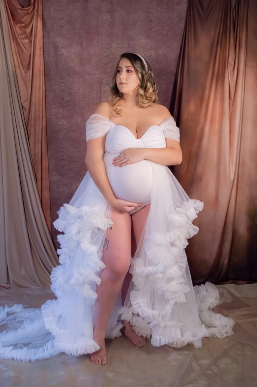 a pregnant woman is posing in white