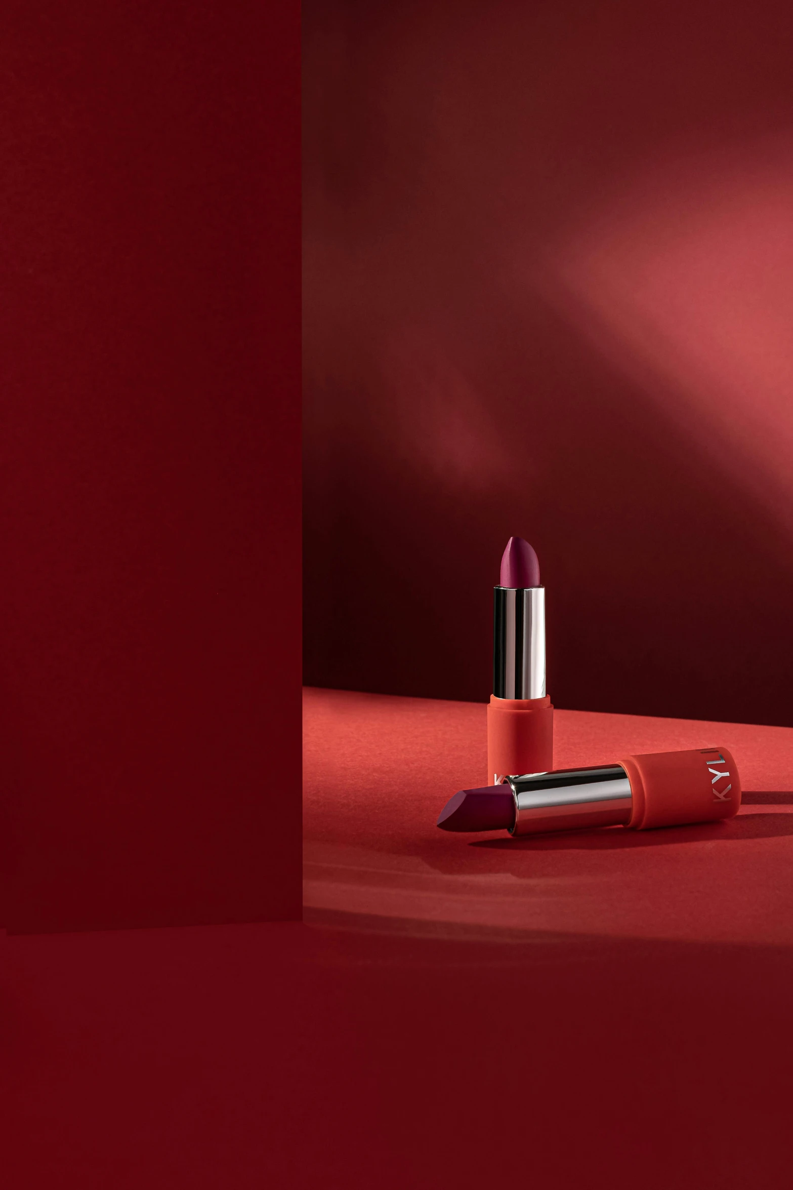 a lipstick on a red background with spotlights