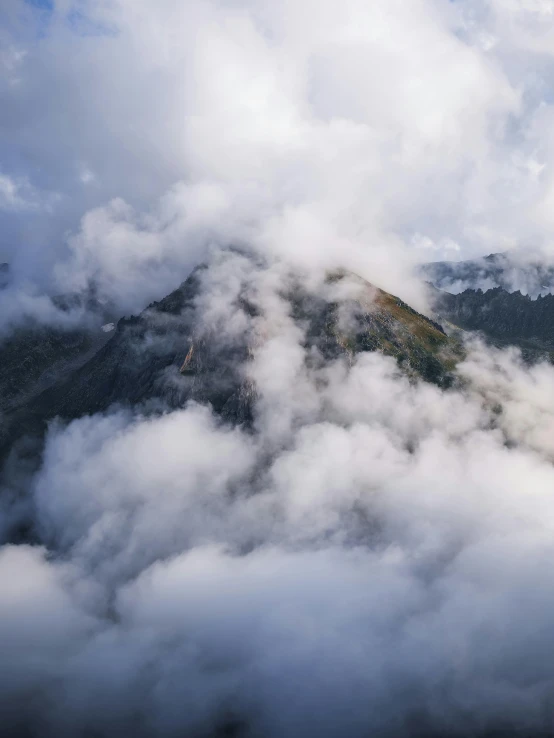 a small mountain is covered with clouds and fog