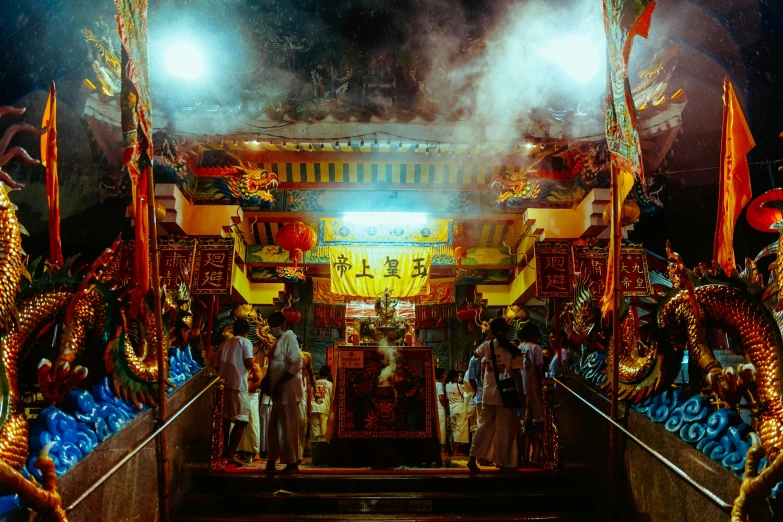 three people are walking up some steps with dragon like decorations and flags on them