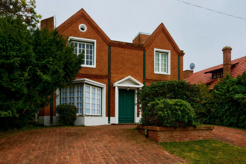 a brick home with a green door is located in the backyard