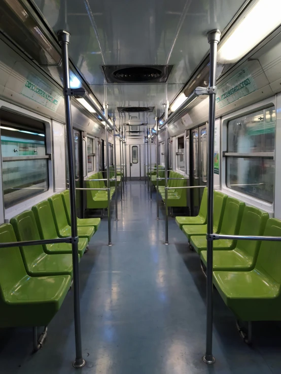 an empty subway train with four green seats