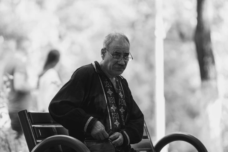 an older man sitting on a bench in front of a bicycle