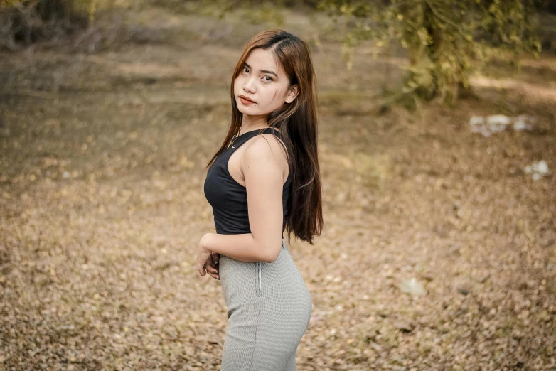 a woman is standing in the field with her hand on her hip