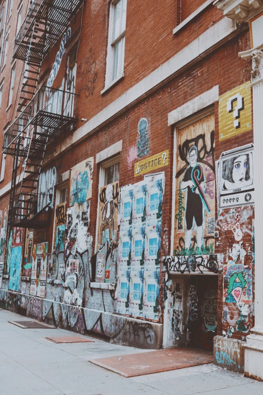 a building with graffiti and windows with fire escapes