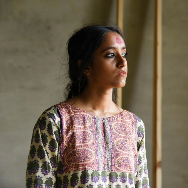 a woman standing in front of a wall