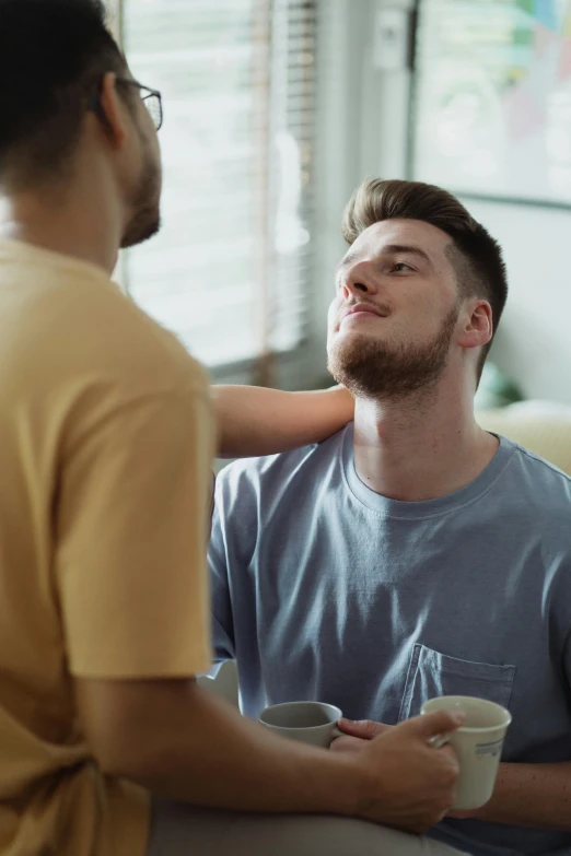 a guy that has some coffee in his hand and is giving another person