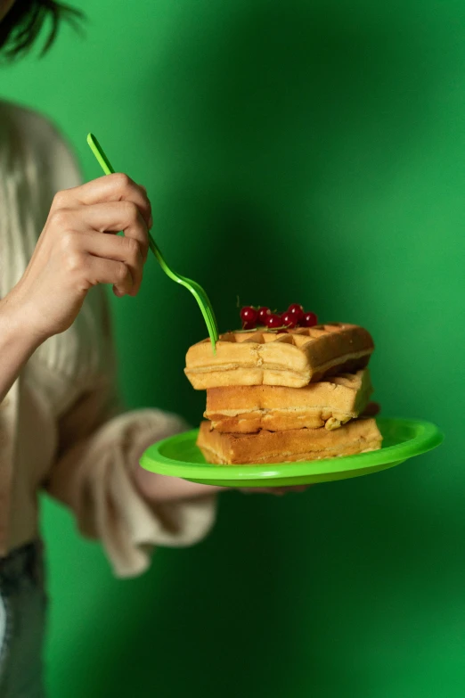 a woman holding a plate with waffles and berries