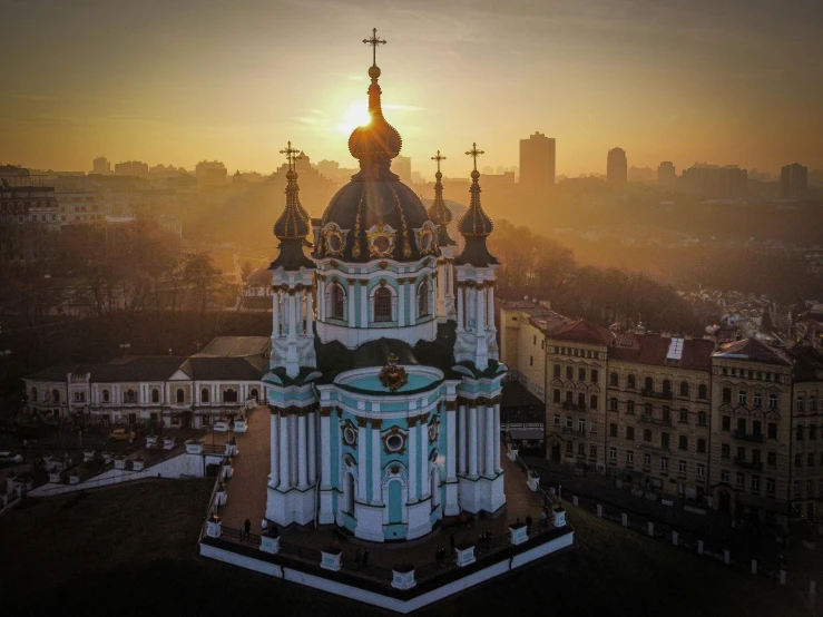 a large clock tower in a city during the sun set