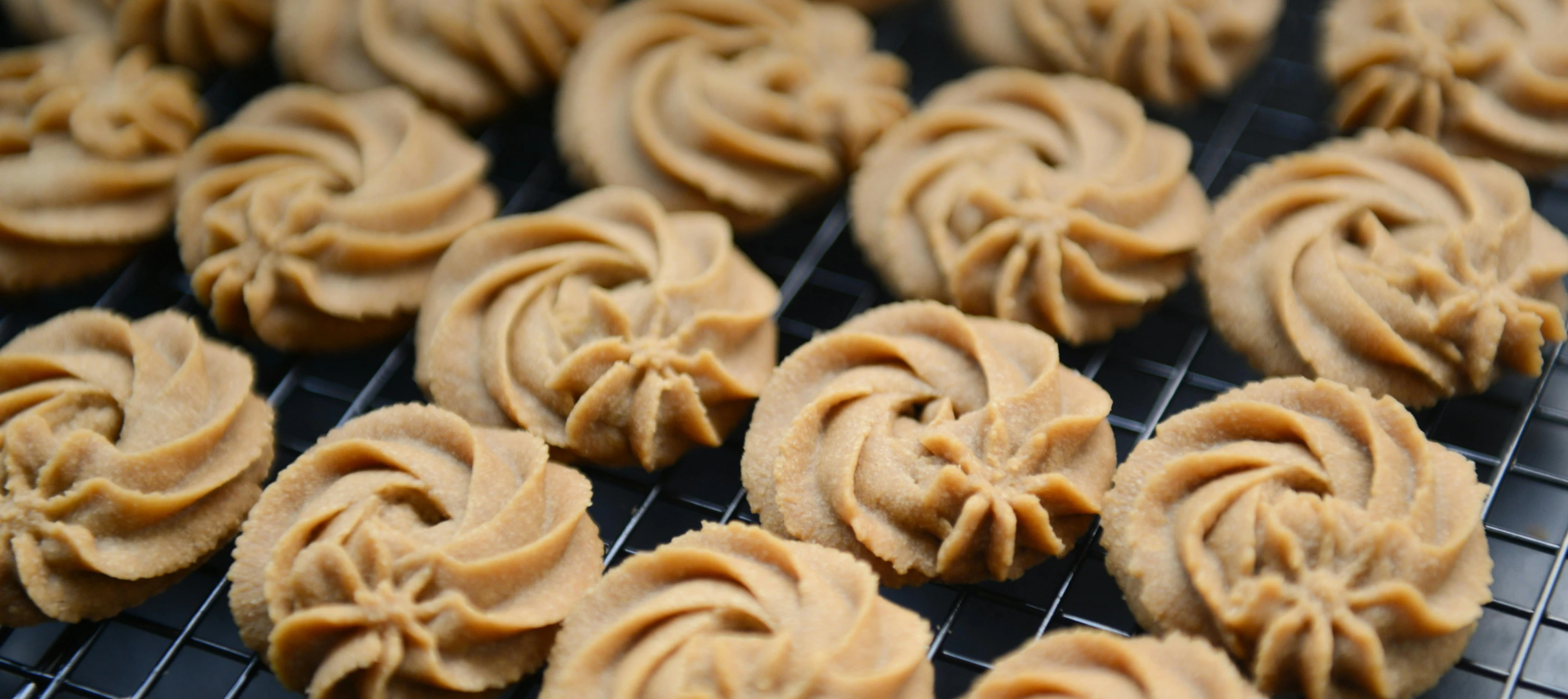 a black rack topped with cookies covered in peanut er