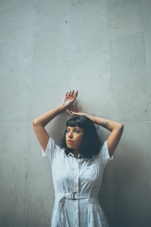 woman covering her eyes while standing with one hand on the top of the head