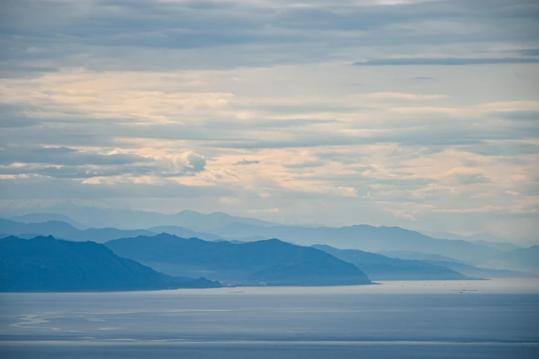 an airplane is flying above the ocean on a cloudy day