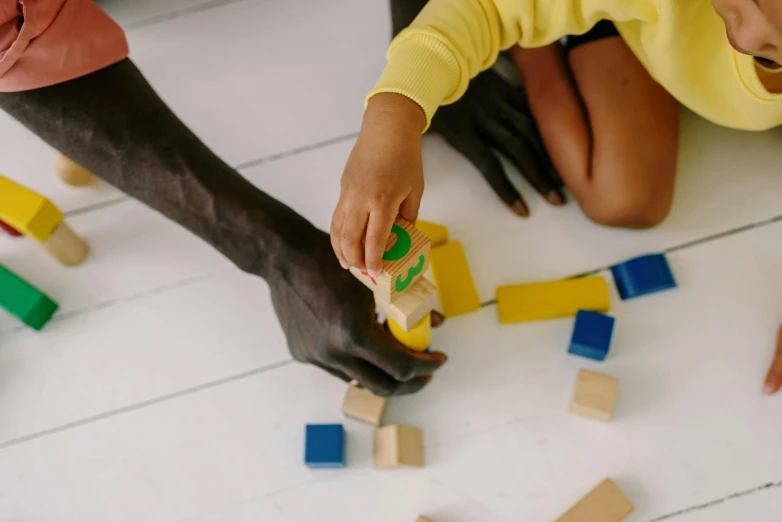 three s playing with blocks on the floor