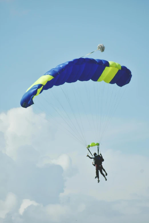 a man flying with a parachute through the sky