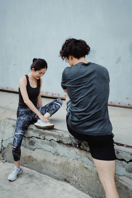 two people doing soing with a skateboard and standing on concrete