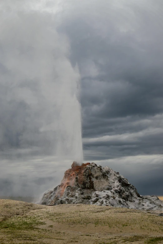 an old fashioned geyser erupts steam in the air