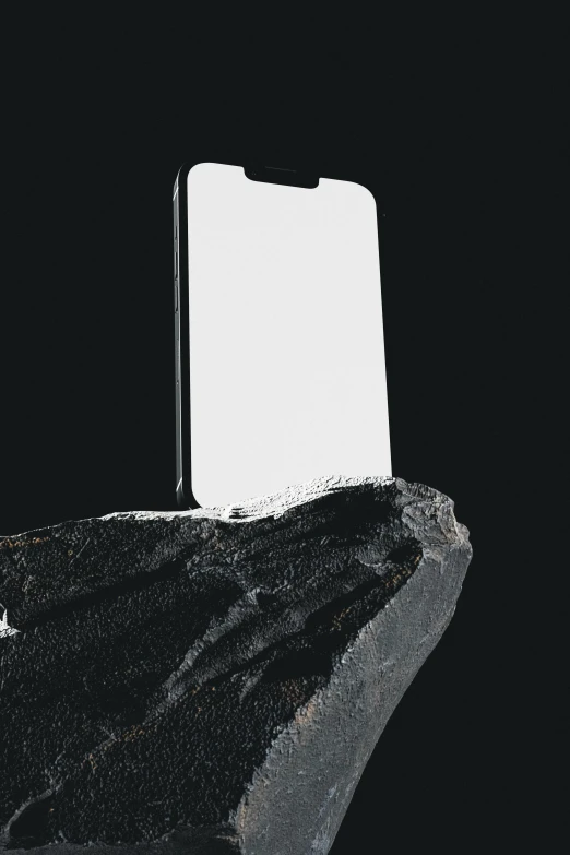 an artistic cell phone on a rock in the dark