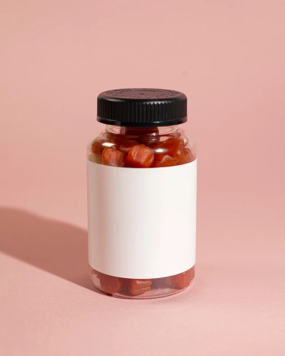 a jar of candy sitting on a pink surface