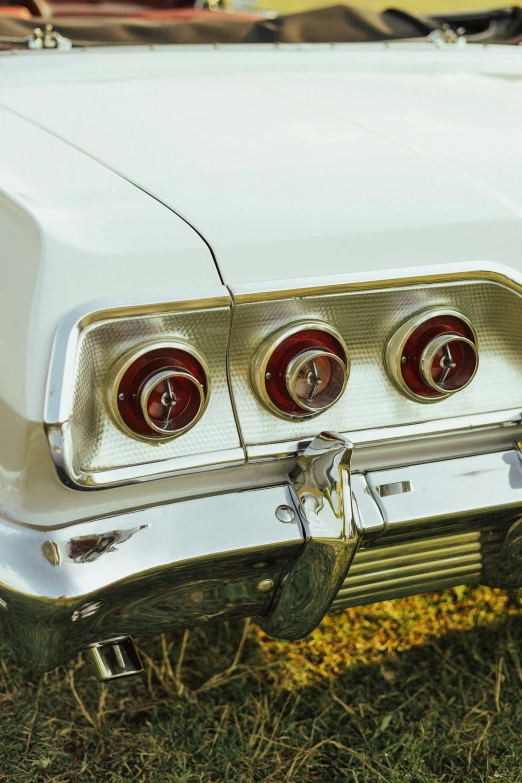 a white vintage car sitting on top of a field