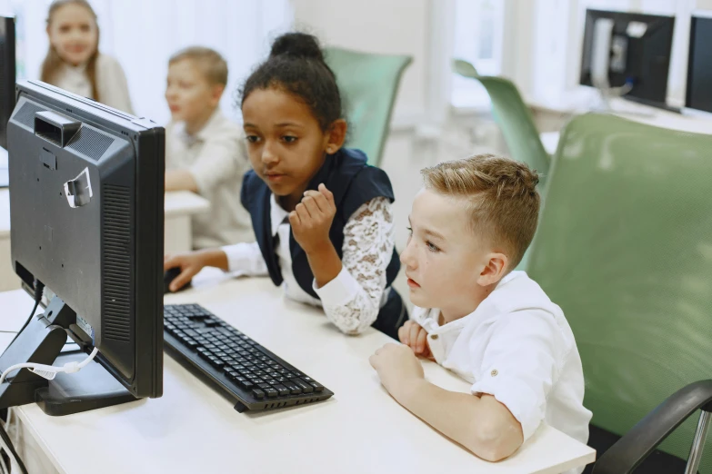 children at a computer screen and onlookers