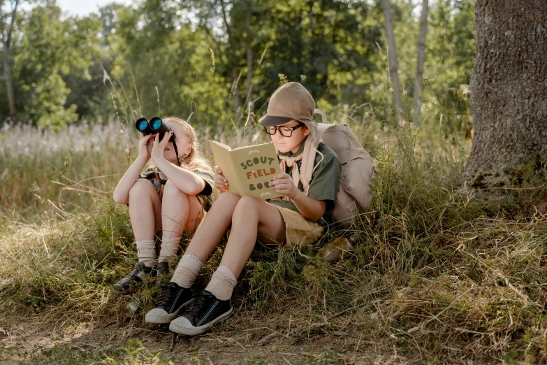 a couple of people sitting down in the grass