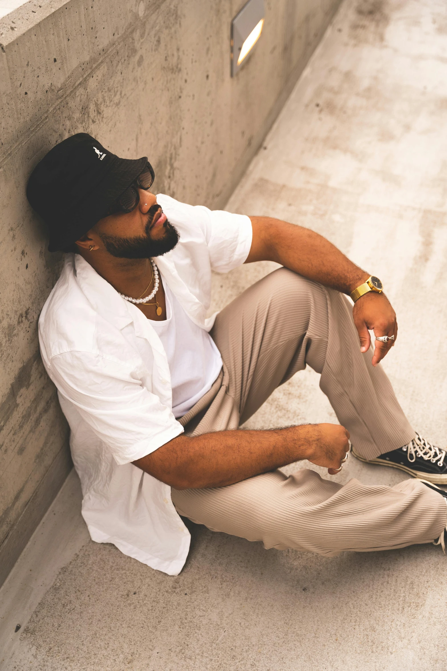 a man in white shirt and cap sitting on cement steps