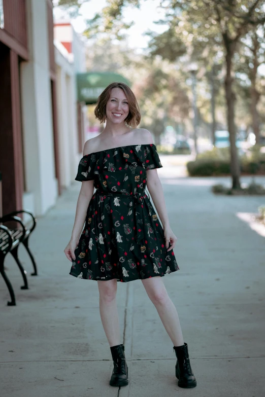 a woman wearing black is standing on the sidewalk