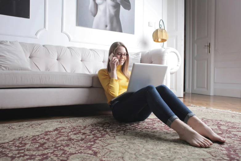 a woman on the floor with a laptop in her lap