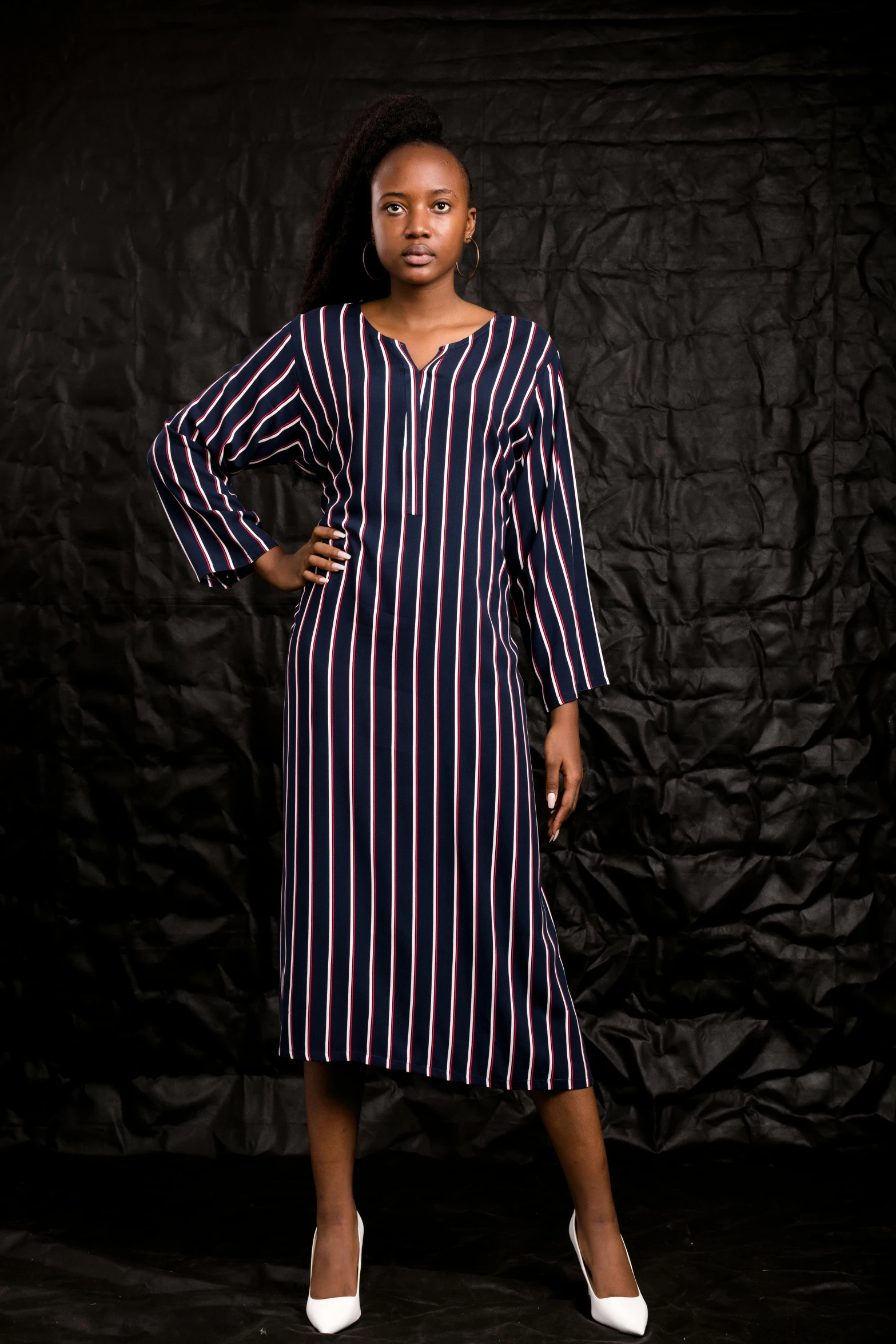 a young woman standing in a black and red striped dress