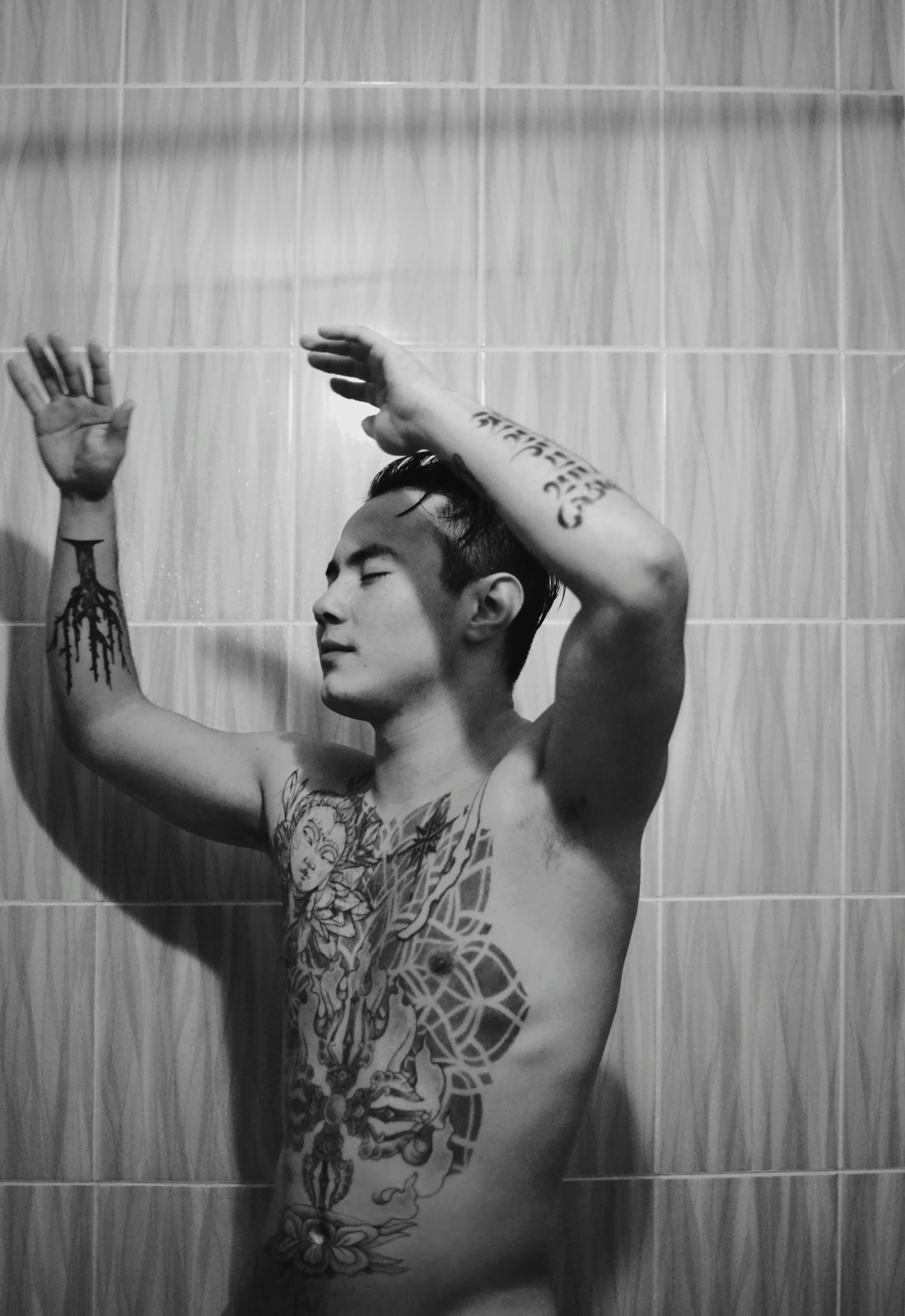 a shirtless man standing in front of a shower