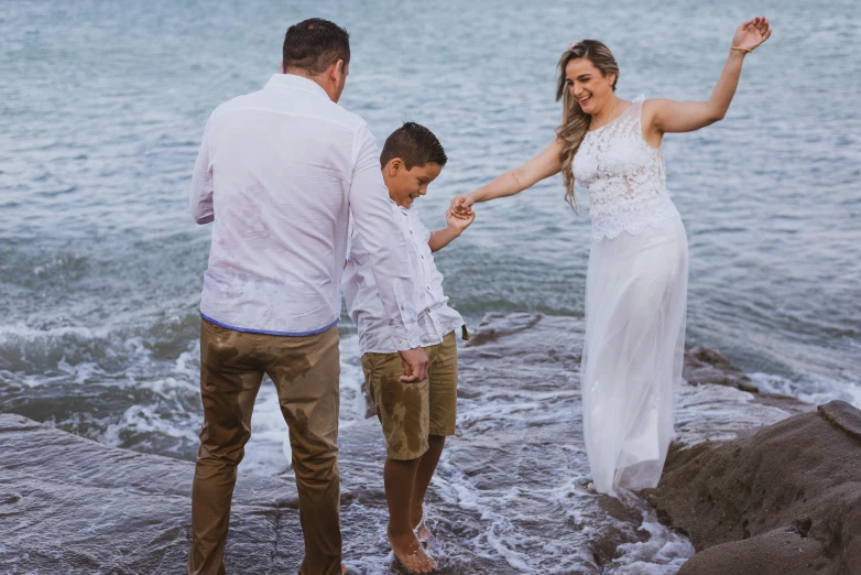 a man and woman are holding hands as the child holds up his arm