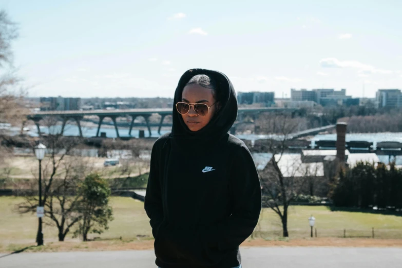 a woman in a hoodie is looking at the camera