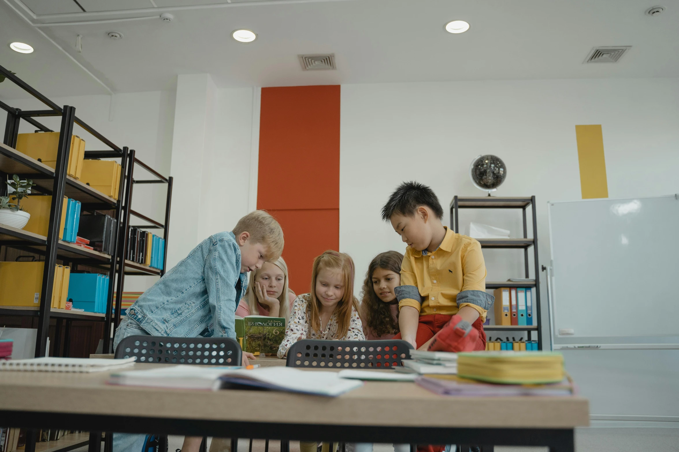 three people watching two children at a table