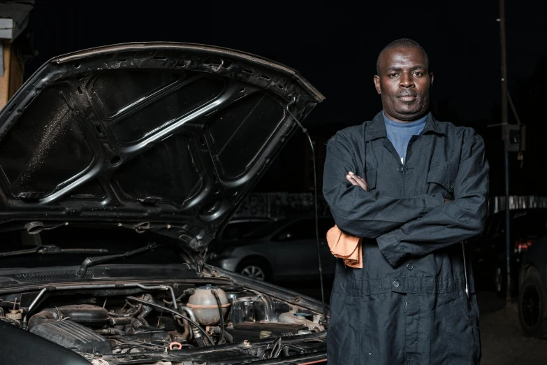 a man is standing next to the hood of his car