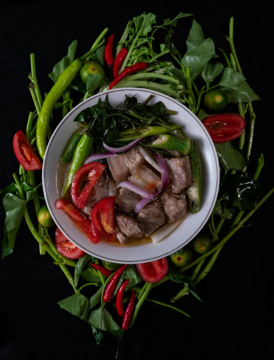 a white bowl filled with food on top of greens