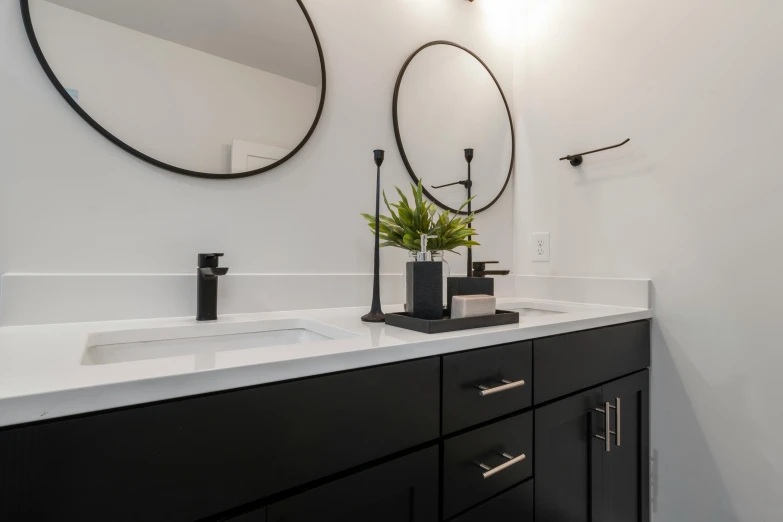 a bathroom vanity with mirrors and lamps above it