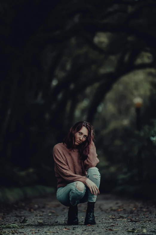 a young woman in jeans and boots posing for a po