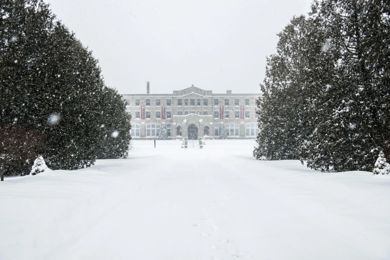 a large snow covered house in front of trees