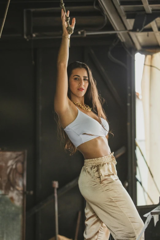 a woman in high waist jeans and a white crop top holding a string