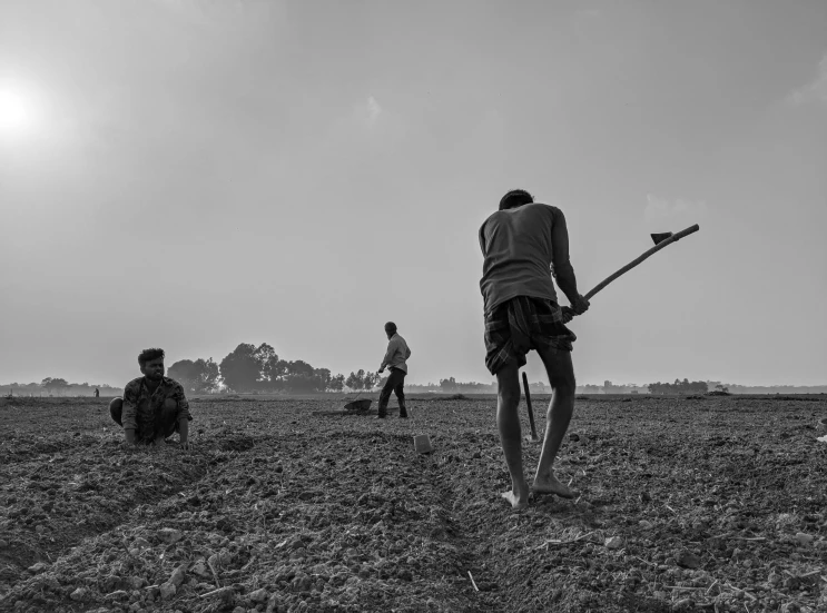 a man holding a baseball bat with people sitting and standing in the background