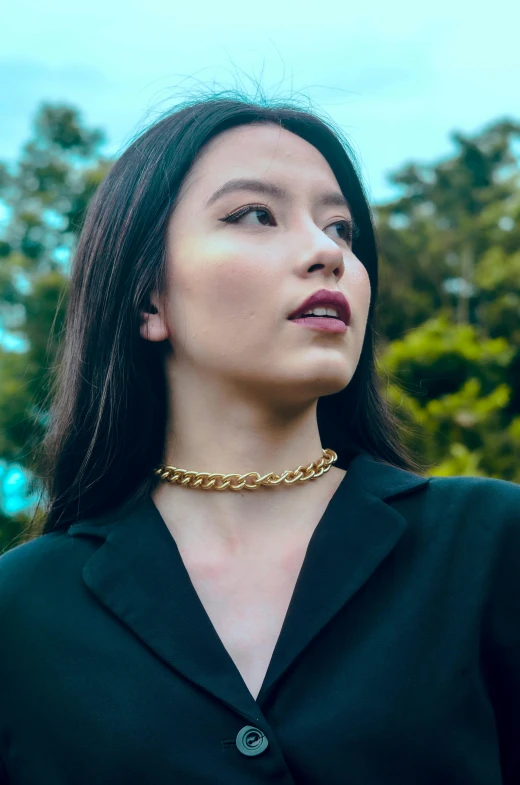 a close up of a woman wearing a gold necklace