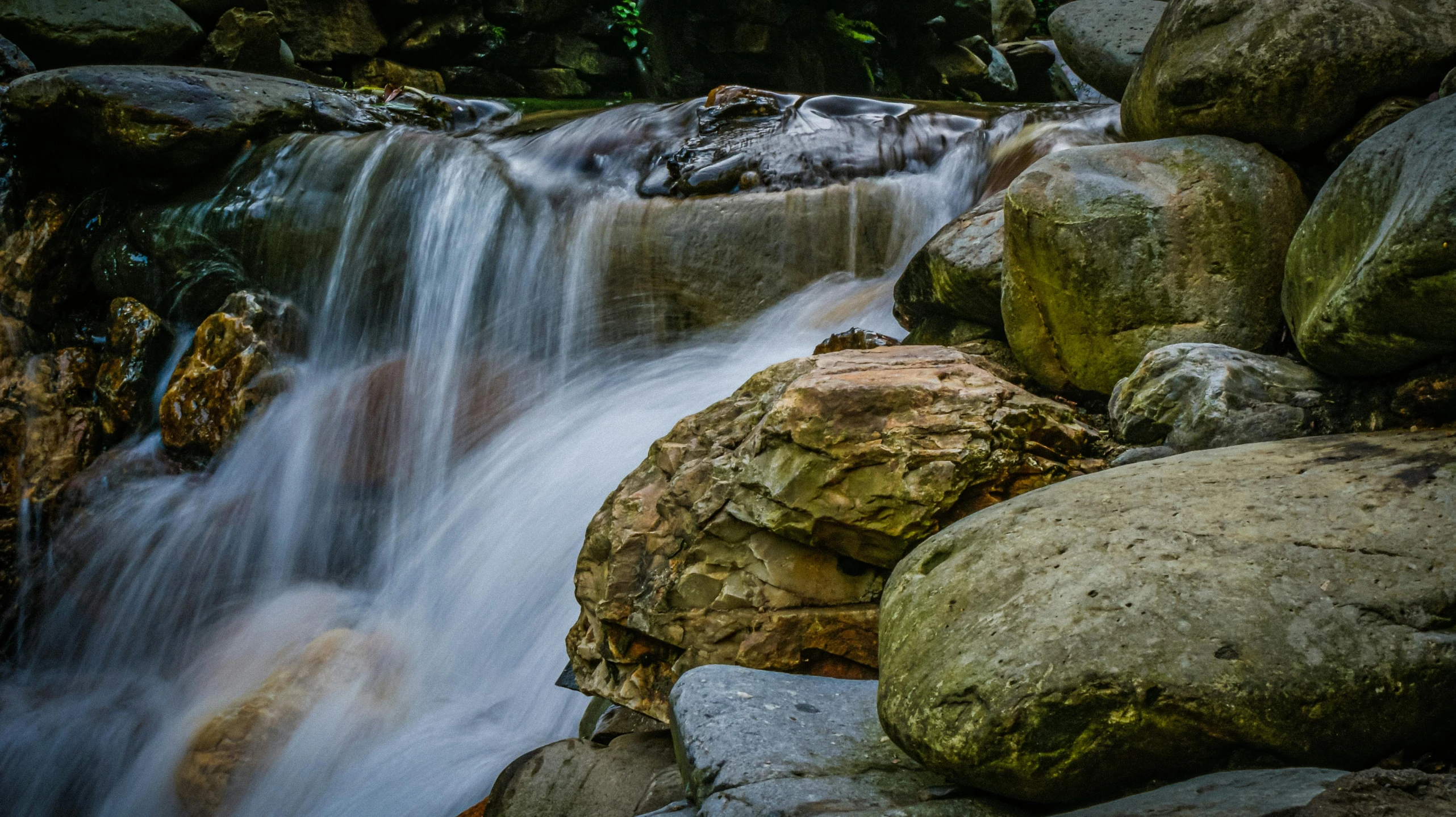 a group of rocks sitting next to a waterfall