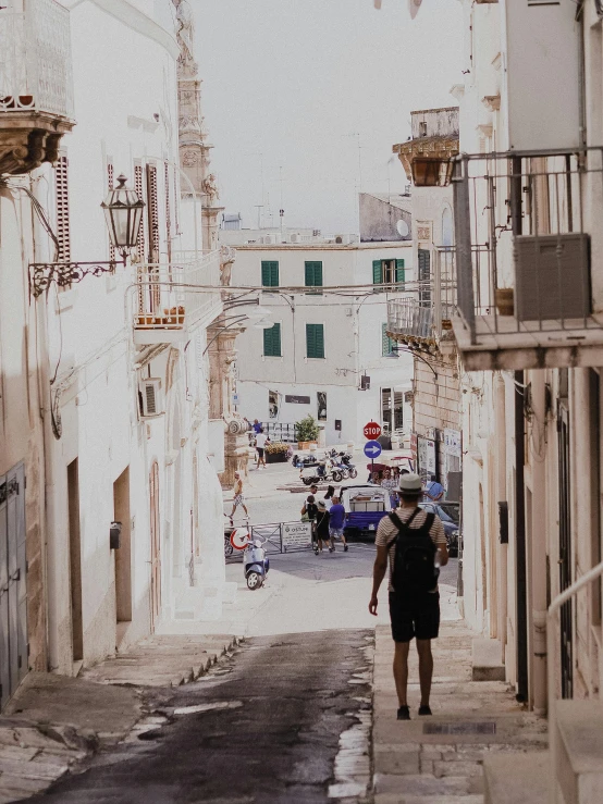 man walking down the middle of a narrow street in a town